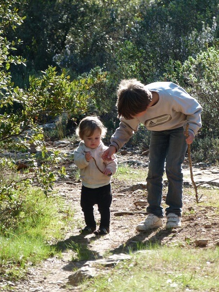 Bébé aprenant à marcher avec un enfant